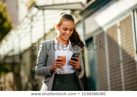 Foto stock: Woman With Smartphone Walking On Street