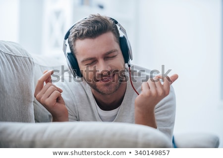 Stockfoto: Young Man Listening To Music On His Couch