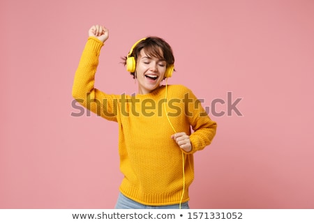 Stockfoto: Cheerful Brunette Woman In Sweater And Headphones Listening Musi