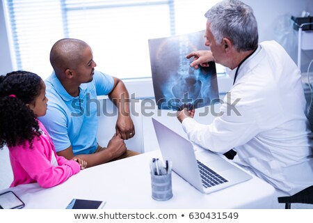 Foto d'archivio: Doctor Discussing X Ray Report With Father And Daughter