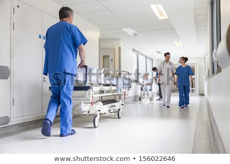 Foto stock: Nurse Pushing A Male Patient In A Wheelchair