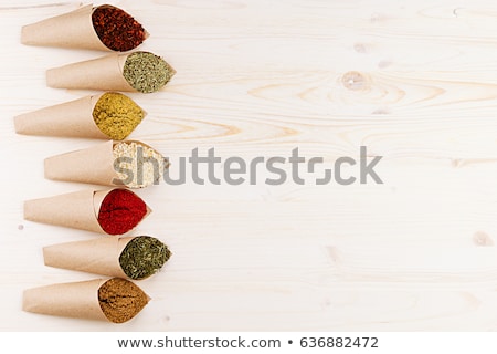 Stockfoto: Decorative Border Of Various Powder Spices Close Up In Paper Corners On White Wooden Board With Copy