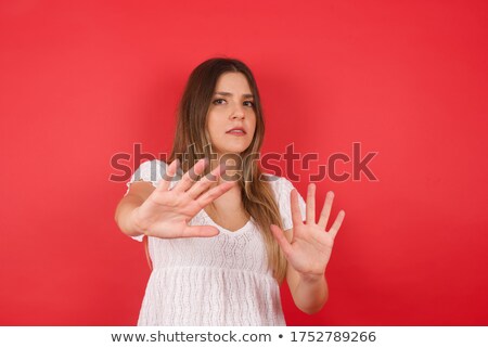 Foto d'archivio: Serious Young Beautiful Woman Isolated Over Blue Wall Holding Citrus Near Ear Wearing Hat Showing Si