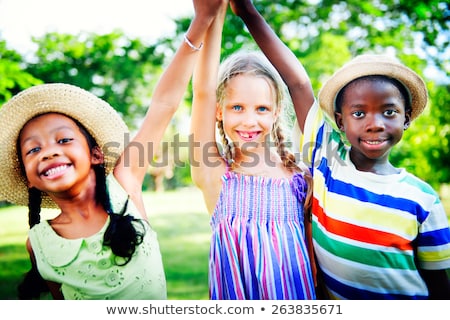 Foto stock: Happy Kids Holding Raised Hands In Summer Park