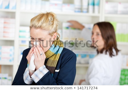 Stok fotoğraf: A Woman Blowing Her Nose At The Doctor