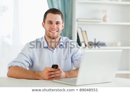 [[stock_photo]]: Young Businessman With His Cellphone In His Homeoffice