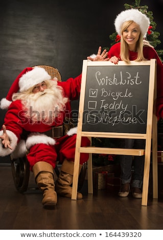 Stock photo: Santa Claus With His Helper Standing Near Chalkboard With Wishli