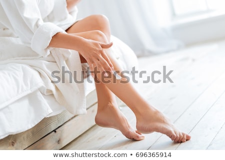 Foto stock: Young Woman In Bathrobe Applying Cream