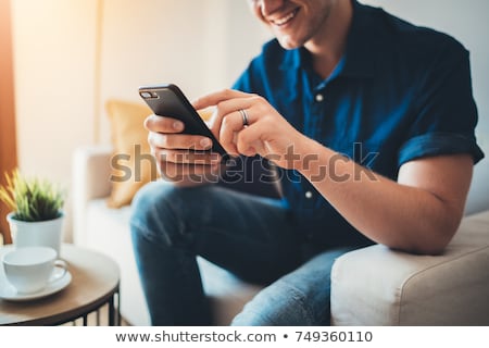 Stock fotó: Smiling Young Businessman Using Smartphone