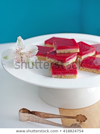 Stok fotoğraf: Raspberry Shortcrust Layered Pastry Squares On A White Plate Turquoise Background