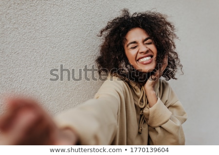 Stok fotoğraf: Portrait Of An Excited Woman With Dark Curly Hair