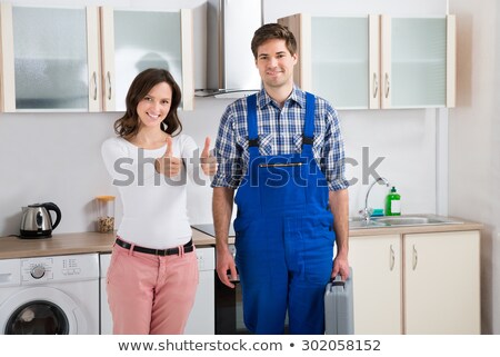 Сток-фото: Woman Standing With Repairman Showing Thumbs Up Sign