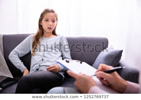 Foto stock: Psychiatrist With Clipboard Sitting Near Girl