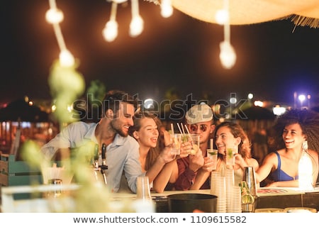 Foto stock: Friends Drinking Cocktails In Beach Bar