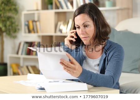 Foto stock: Confused Woman With Documents In Hands