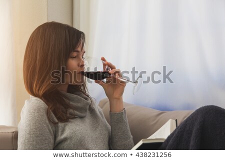 Foto stock: Ma · jovem · deitada · no · sofá, · bebendo · vinho