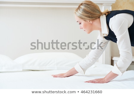 Foto d'archivio: Housekeeper Making Bed In Hotel Room
