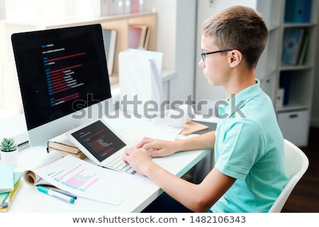 Сток-фото: Diligent Schoolboy In Casualwear Looking Through Information On Computer Screen