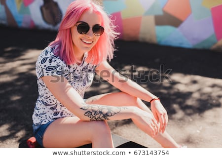 Stok fotoğraf: Young Woman Sitting Waiting On Her Skateboard