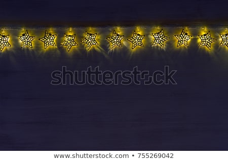 Stockfoto: Sparkling Lights Stars Burn On Dark Blue Wood Board Evening Magic Serene Background