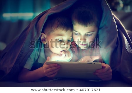 Foto d'archivio: Little Kids With Tablet Pc In Bed At Home