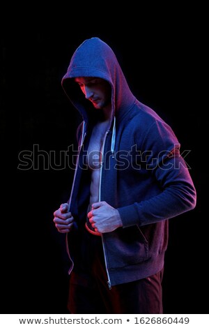 Zdjęcia stock: Young Male Athlete In Dark Blue Unzipped Hoodie Standing In Darkness