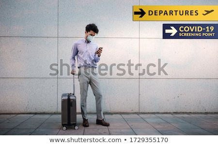 Сток-фото: Businessman With A Suitcase And A Surgical Mask