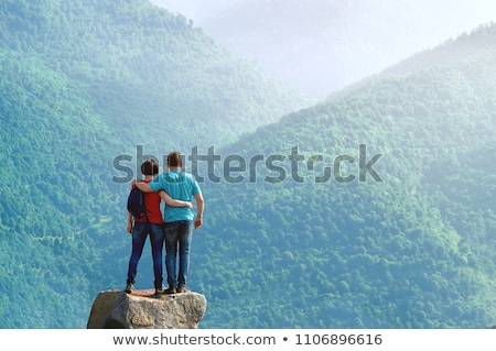 Stok fotoğraf: Young Man On A Rock In The Middle Of The Nature