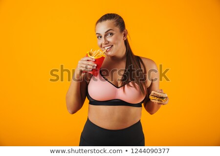 Foto d'archivio: Image Of Happy Chubby Woman In Tracksuit Holding Sandwich And Fr