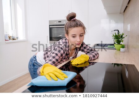 Foto stock: Woman Wearing In Protective Glove With Rag Cleaning Electric Stove At Home