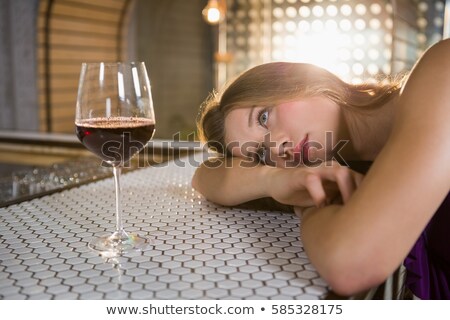 Foto stock: Woman Lying On Bar Counter With Wine Glass On Table