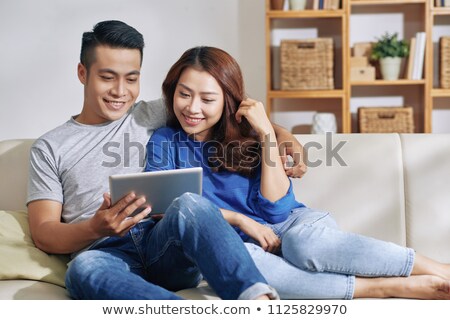 Stockfoto: Charming Couple Surfing Tablet On Couch