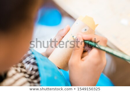 Сток-фото: Hand Of Contemporary Youthful Schoolboy With Crayon Drawing Face On Rolled Paper