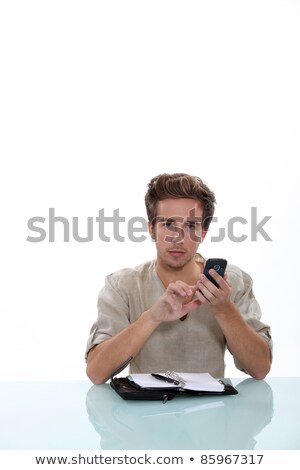 Stok fotoğraf: Man Sitting A Desk With A Cellphone And Personal Organizer