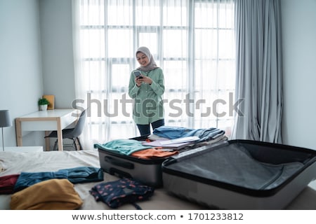 ストックフォト: Woman Packing Her Clothes Into A Suitcase