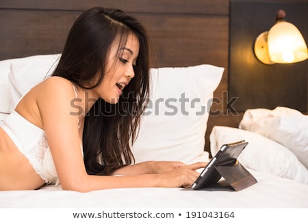 Asian Young Woman Wear Underwear Playing Tablet On The Bed In Th Foto stock © ChaNaWiT