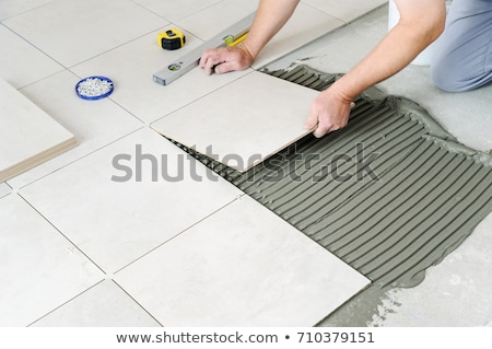 Foto stock: Worker Tiler Puts Ceramic Tiles