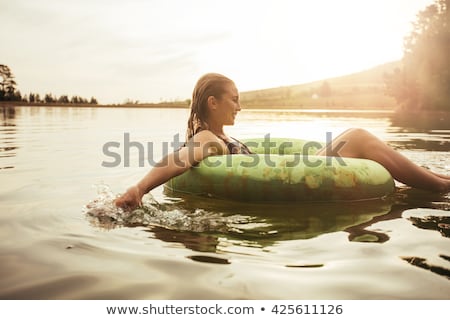 Foto d'archivio: Woman Bikini Sitting On The Lake Side