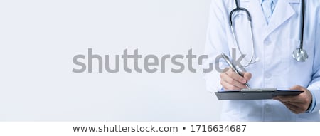 Foto stock: Female Doctor In White Uniform Writing On Clipboard Paper