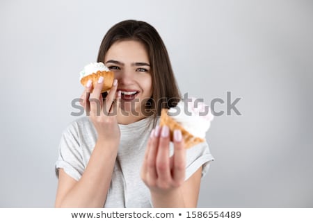 Stock fotó: Two Young Happy Girls In White Shirts Eating Cupcakes