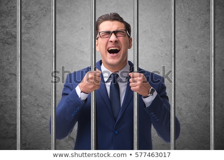 Foto stock: Young Businessman Behind The Bars In Prison