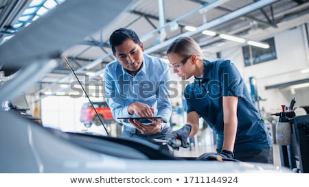 Stock photo: Mechanic Man With Lamp Repairing Car At Workshop