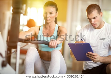 Foto stock: Woman Exercise In A Gym With The Help Of Her Personal Trainer