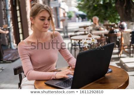 [[stock_photo]]: Beautiful Woman Sitting Outdoors Using Laptop Computer With Earphones