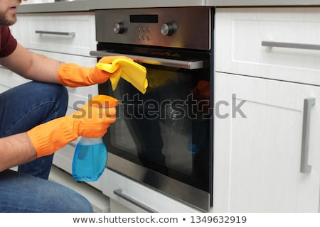 Zdjęcia stock: Man With Rag Cleaning Oven Door At Home Kitchen