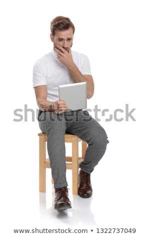 Foto stock: Shocked Seated Man Reads Something On His Tablet