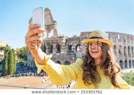 Foto stock: Woman Taking Photo Of Colosseum