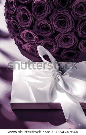 Foto stock: Luxury Holiday Silk Gift Box And Bouquet Of Roses On Purple Back