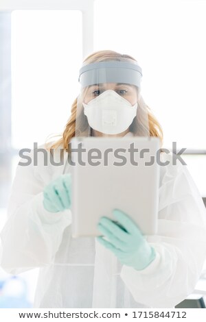 Foto stock: Front View Of Caucasian Female Surgeons Wearing Latex Gloves Before Operation In Dark Operation Room