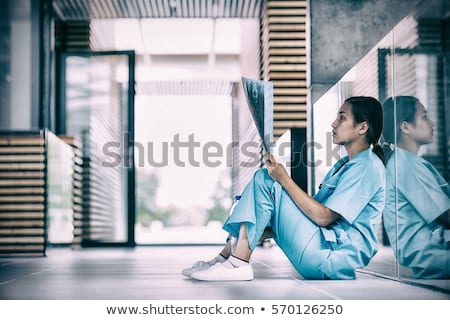 Imagine de stoc: Stressed Nurse Examining X Ray Report